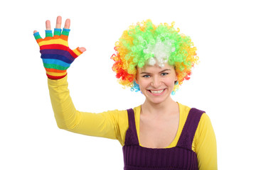 Funny girl in colored curly wig shows hand in multicolor glove