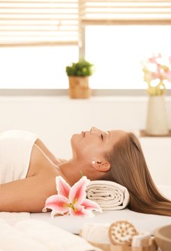 Attractive woman lying on massage bed in spa.