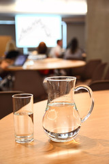 decanter and glass with clean clear water on light table in room