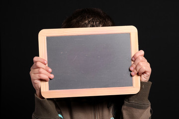 bambino nascosto dietro piccola lavagna