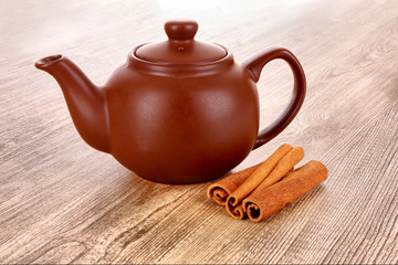 Cinnamon bark and teapot on wooden table