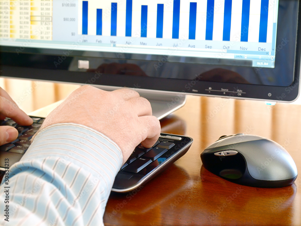 Fototapete man's hand typing at a computer keyboard.
