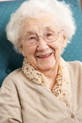Senior Woman Relaxing In Chair At Home
