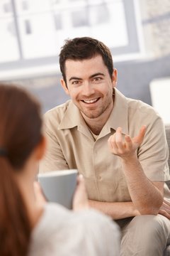 Portrait of happy man chatting with woman at home