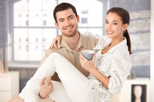Happy man holding woman in his arms smiling