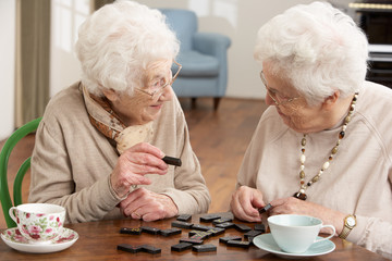 Two Senior Women Playing Dominoes At Day Care Centre