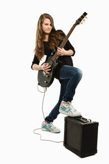 Happy teenager girl playing guitar