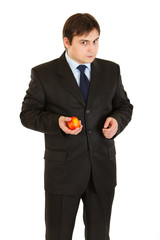 Thoughtful modern businessman holding apple in hand