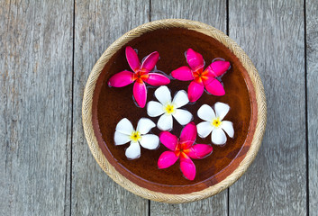 Obraz na płótnie Canvas Colorful Plumeria flower floating in the ancient bowl