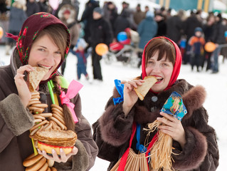 Happy girls eating pancake during  Shrovetide
