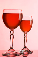Wine glasses with wine on a pink background
