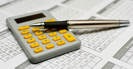 Pencil  and calculator with yellow buttons on calender 2011