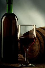 Still life with wineglass and bottle on the desk