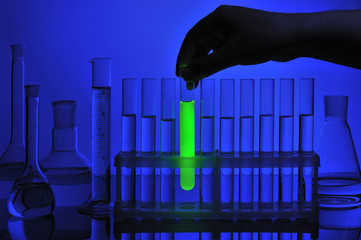 Hand takes test tube from support
