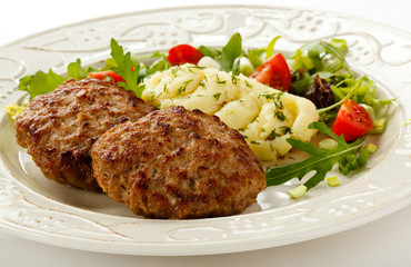 Fried steaks with mashed potatoes and vegetable salad