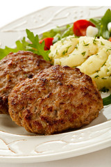 Fried steaks with mashed potatoes and vegetable salad