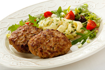 Fried steaks with mashed potatoes and vegetable salad