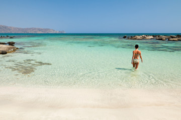 Woman bathing in Elafonisi beach (Crete, Greece) - obrazy, fototapety, plakaty