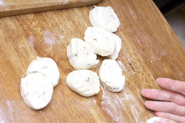 hands in flour closeup kneading dough on table