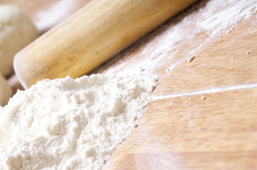 hands in flour closeup kneading dough on table