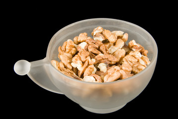 A cup of walnuts isolated on black background