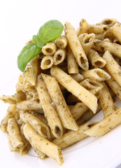 Penne with pesto decorated with basil