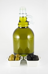 A bottle of olive oil and olives