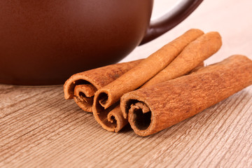 Cinnamon bark and teapot on wooden table