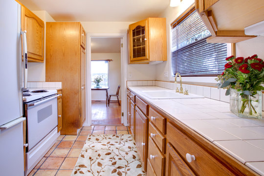 Oak cabinets kitchen with tile floor and flowers