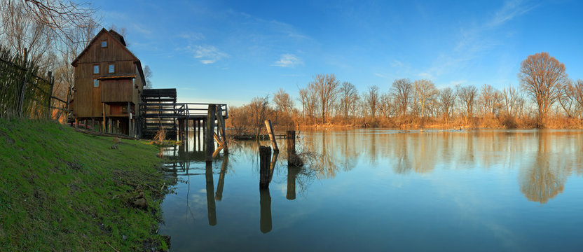River reflection with watermill and tree