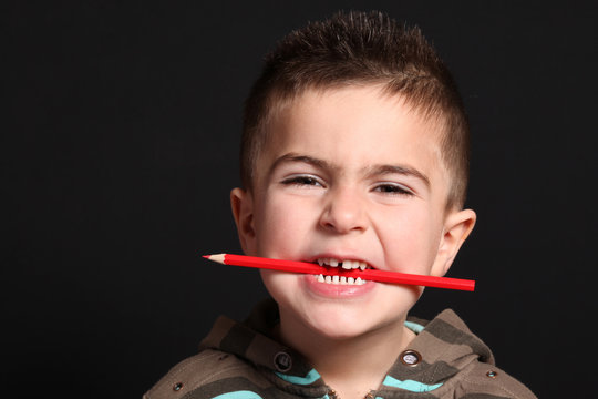 bambino con matita rossa in bocca
