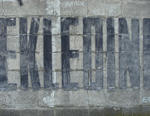 fainted paint publicity fonts on an old stone wall