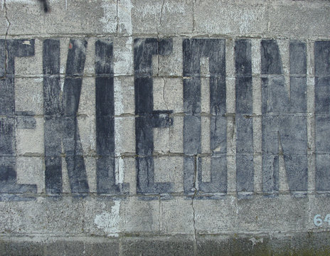 fainted paint publicity fonts on an old stone wall