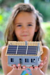 Fillette présentant une maquette de maison.