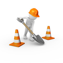 Construction worker digging the ground with traffic cones around