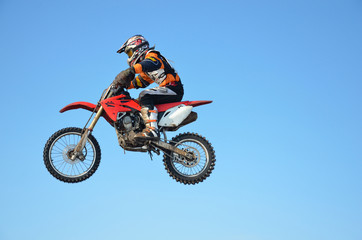 Obraz na płótnie Canvas motocross rider jump, blue sky