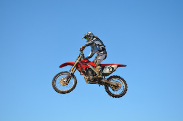 Fototapeta na wymiar Russia, Samara, motocross rider jump, blue sky