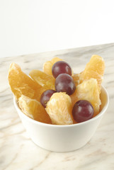 Bol con gajos de naranja y uvas