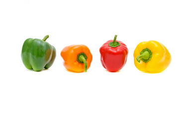 green, red, orange and yellow peppers on a white background