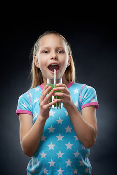 Little girl drinking juice, studio shot