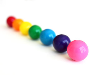 Close-up of colorful gumballs in a row isolated on a white