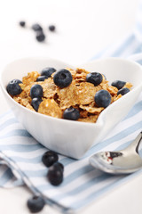 cereal with fresh blueberries and spoon on white background