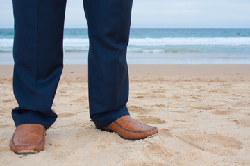 Suit trousers and shoes on the beach