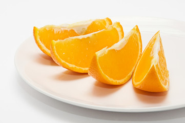 Fototapeta na wymiar four orange slices on white plate isolated