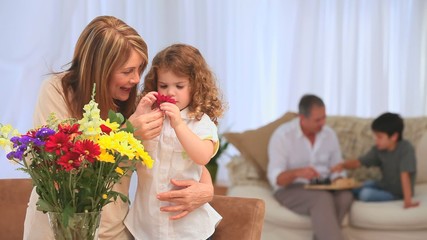 Child smelling flowers with her grandmother - Powered by Adobe