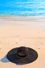 Fototapeta na wymiar hat lay on sand at edge of sea