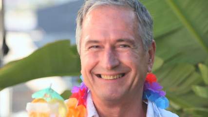 Elderly man with a cocktail and a string of flowers - Powered by Adobe