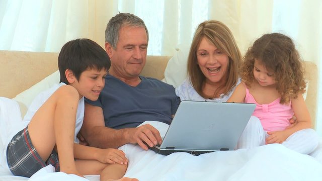 Family laughing in front of  laptop
