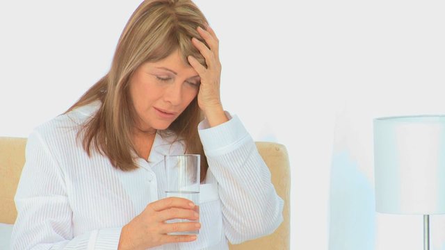 A sick woman with a glass of water
