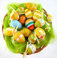 Easter eggs laying on green grass in wicker basket